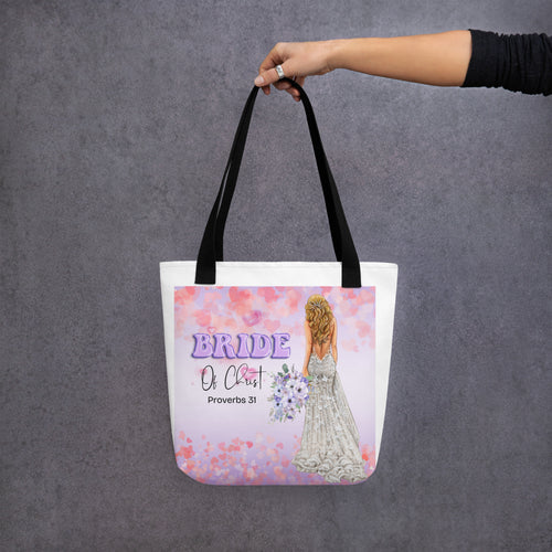 Black handle beige 15x15 canvas tote bag, with square image showing hearts in purple in pink shades, and Balloon text "Bride" in purple with "of Christ" in fancy text with "Proverbs 31" underneath and to the right is back side of Bride, light skin tone, long blonde hair, holding a purple bouquet.